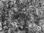 Corroded and pitted cuboidal carbonate crystals by M. Spilde and D. Northup